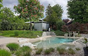 Garten mit Naturpool, Pflanzbereichen und Sitzplatz im privaten Außenbereich